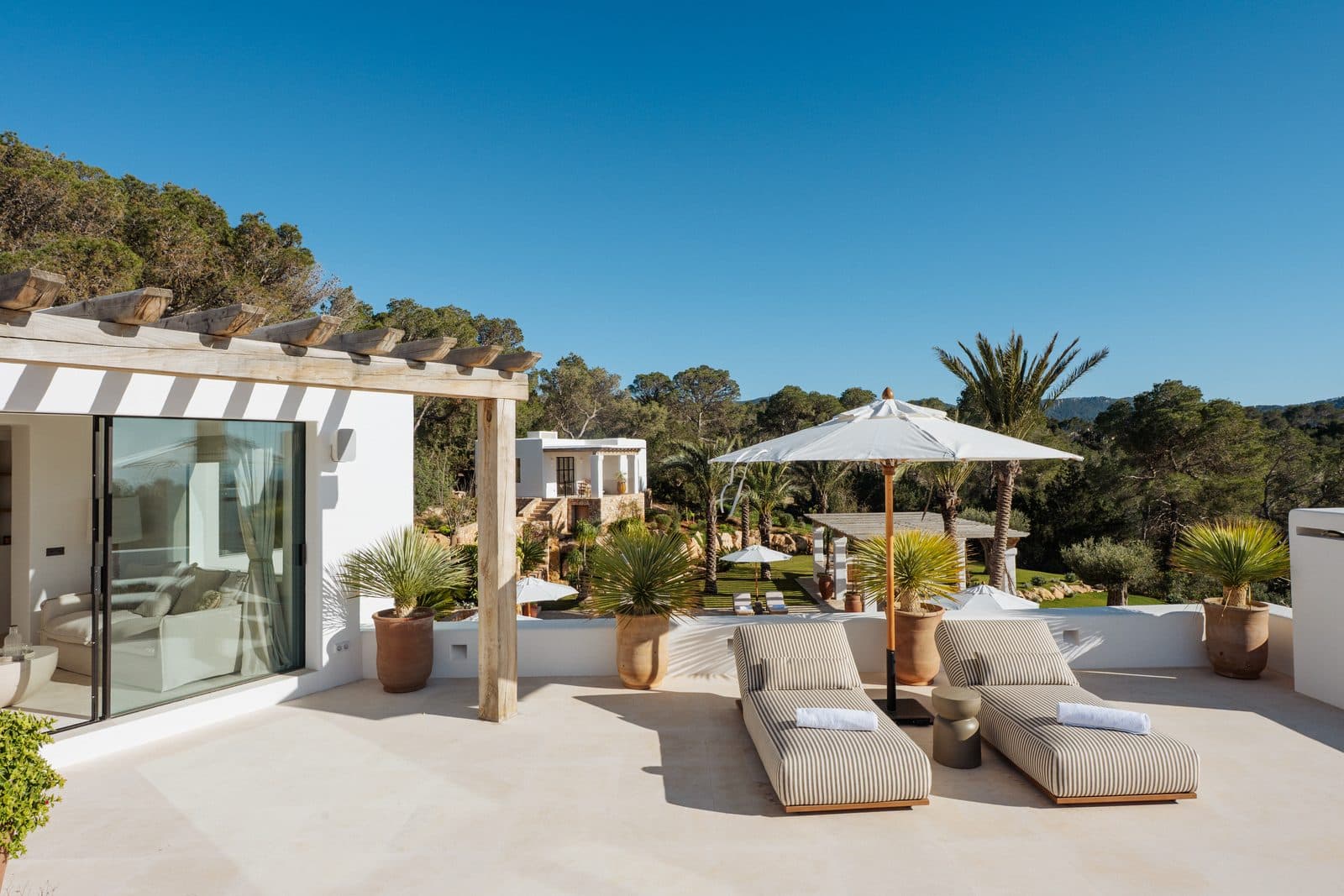 Sunlit villa terrace with pool and loungers
